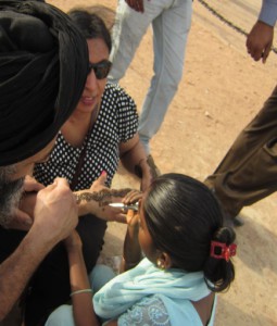 観光客にヘナアートを施す（インド門で）